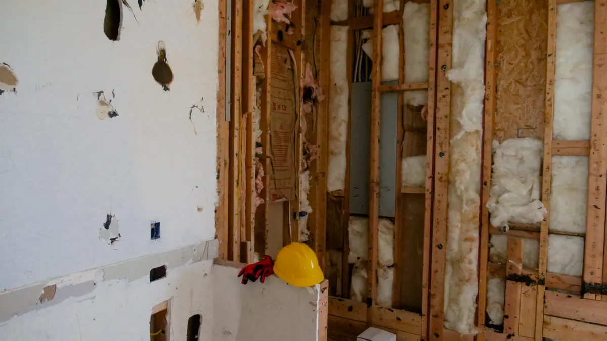 Attic insulation installation: what homeowners should know Exposed wall framing with insulation during renovation