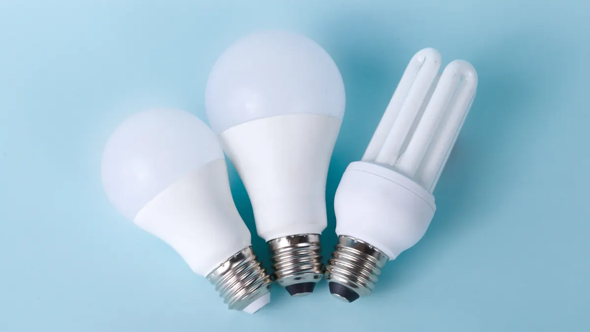 Three energy-saving light bulbs on blue background