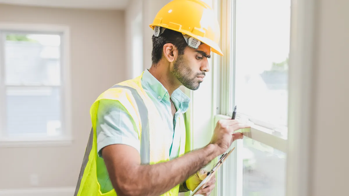 Energy-Efficient Home Upgrades — The Complete Guide Worker inspecting a window frame indoors
