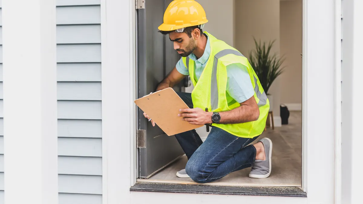 Home energy auditor inspecting a house entryway